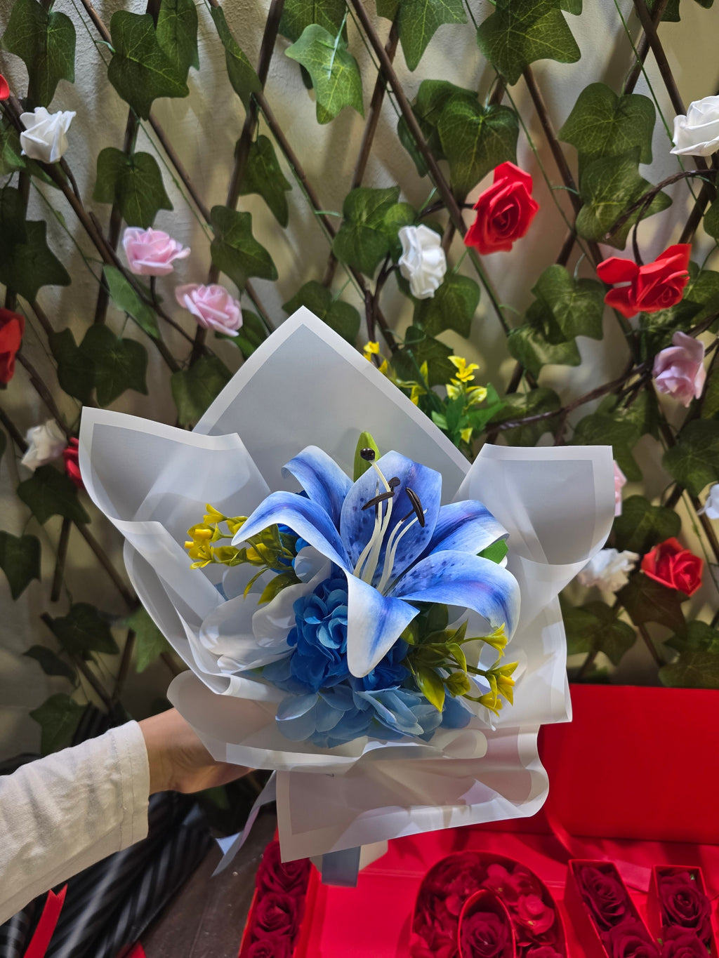 BioCode handcrafted artificial blue lily and hydrangea bouquet wrapped in premium white paper with a blue ribbon.