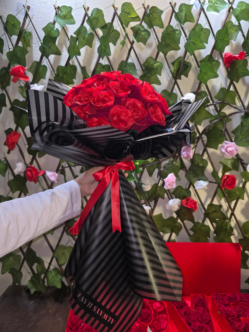 BioCode handcrafted artificial red rose bouquet wrapped in black striped paper with a red ribbon bow
