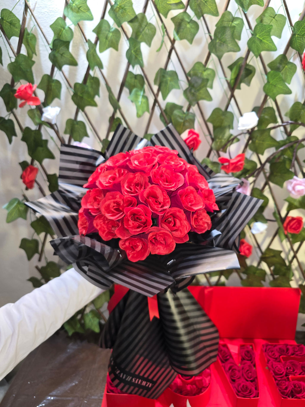 BioCode handcrafted artificial red rose bouquet wrapped in black and white striped paper with a decorative ribbon