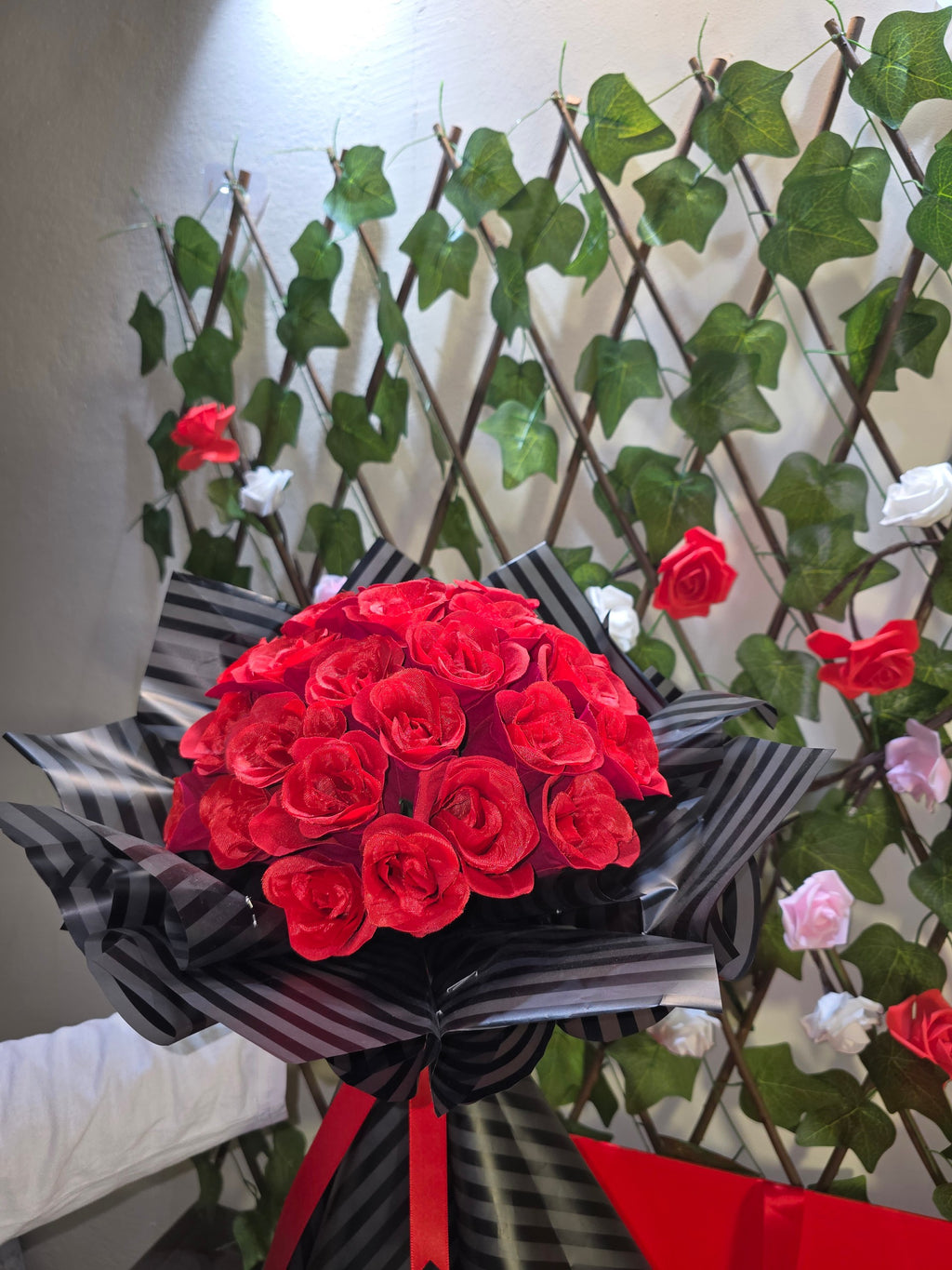 BioCode handcrafted artificial red rose bouquet wrapped in elegant black striped paper with a red ribbon