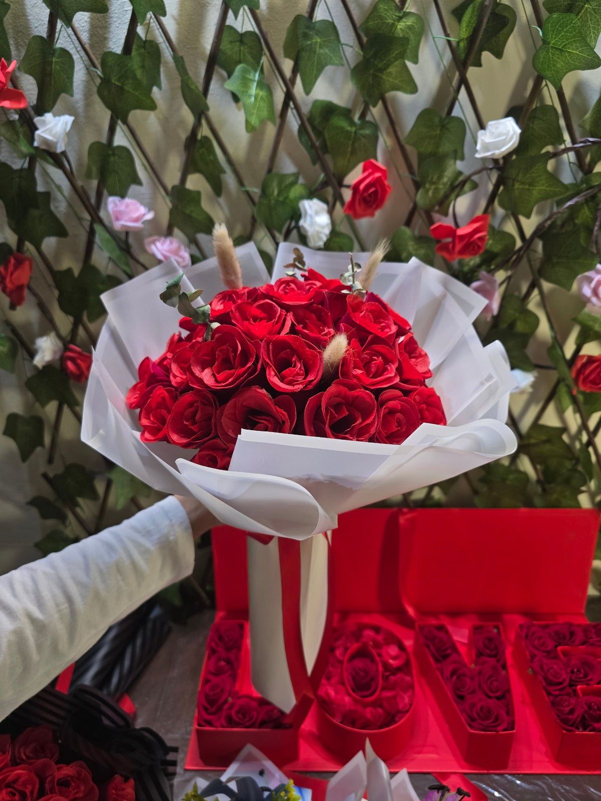 BioCode handcrafted bouquet of artificial deep red roses wrapped in elegant white paper with a decorative ribbon