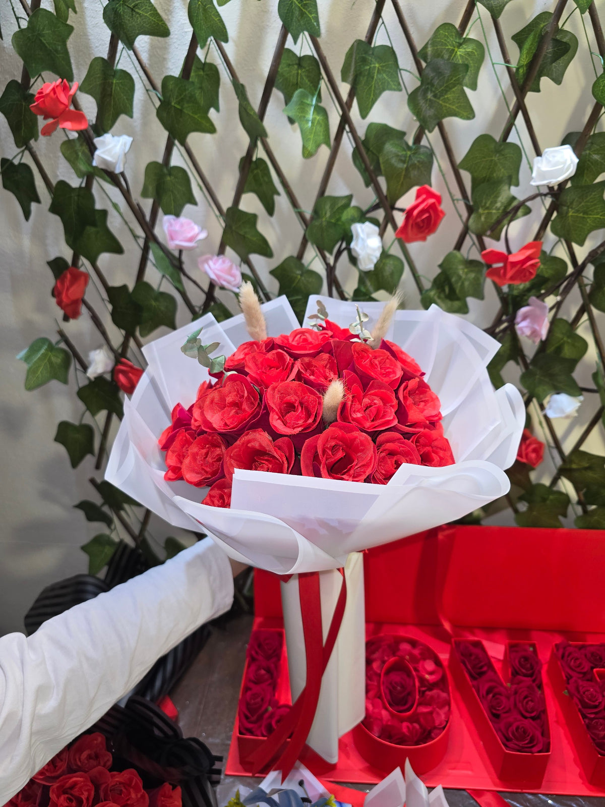 BioCode handcrafted artificial red rose bouquet wrapped in white paper with a red ribbon for romantic occasions