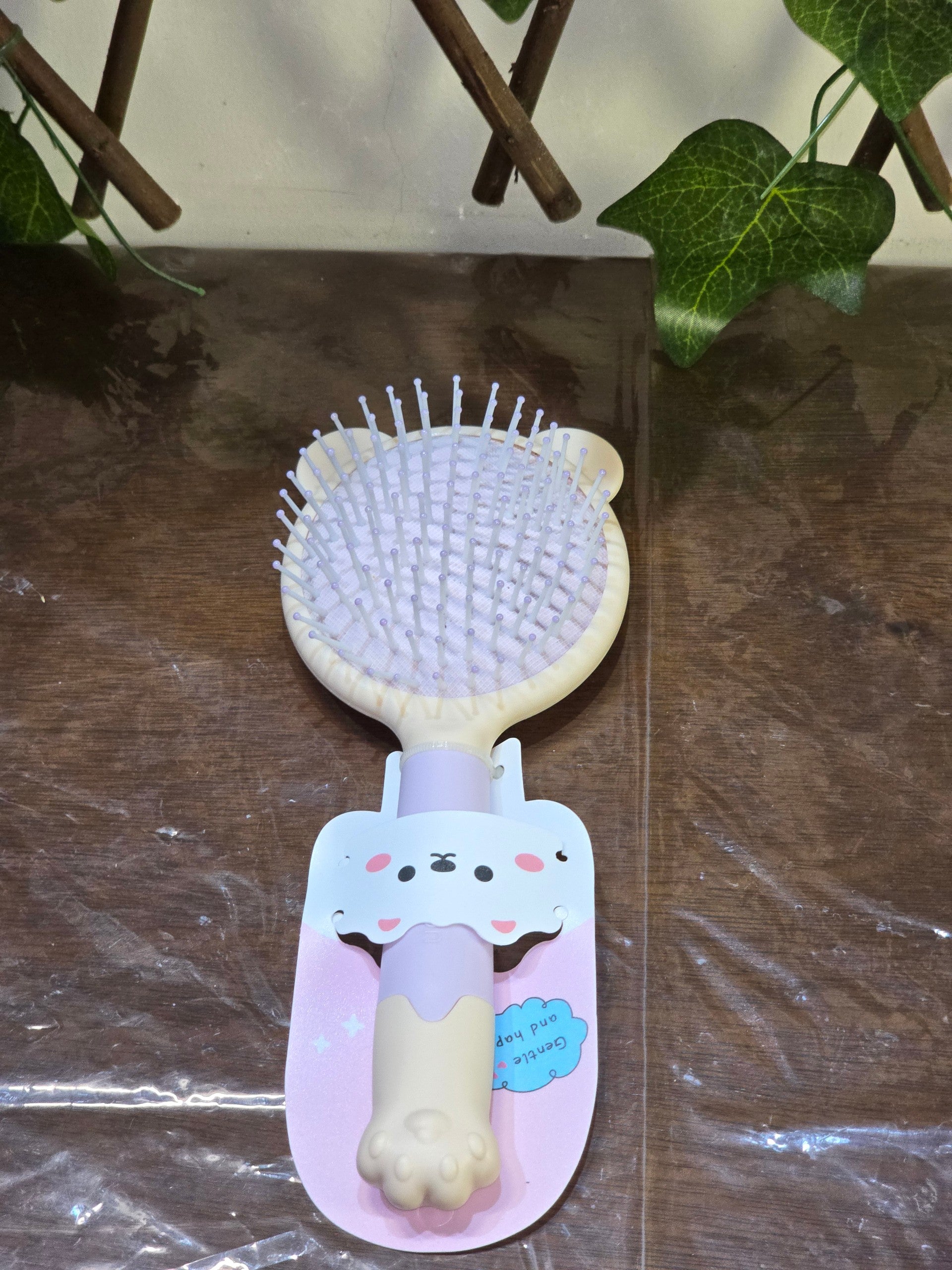 BioCode hairbrush with a cute bear-shaped handle and soft purple accents, designed for gentle detangling.