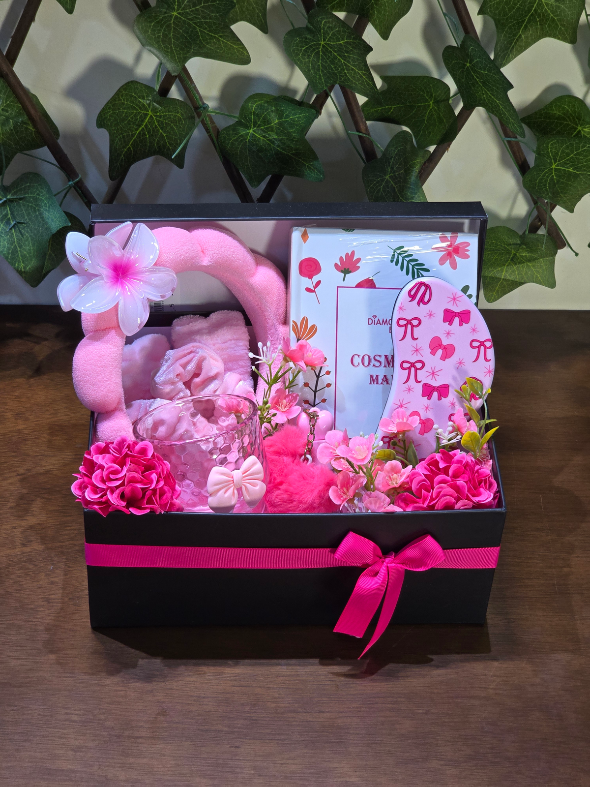 BioCode beauty gift set in a black box with pink ribbon, featuring a headband, cosmetic mirror, and glass tumbler.