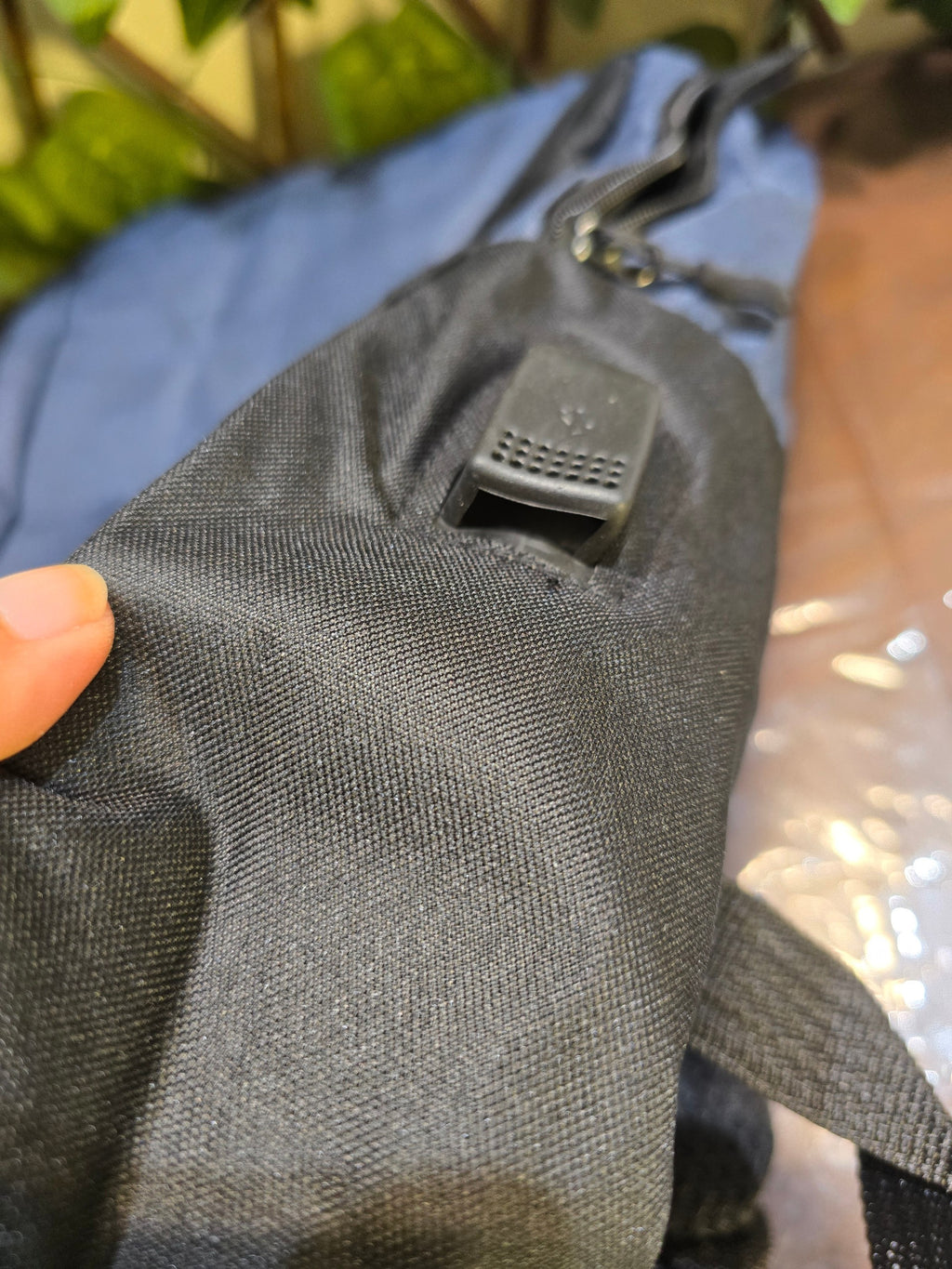 BioCode black water-resistant backpack fabric detail showing the integrated external USB charging port