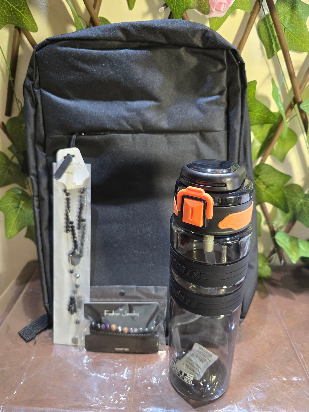 BioCode black everyday backpack with a leak-proof sports water bottle, beaded necklace, and bracelet set.