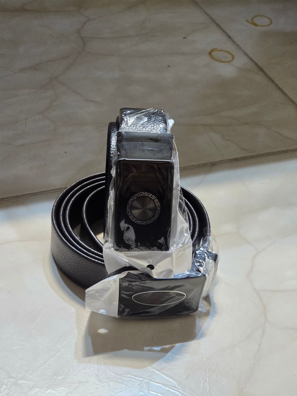 BioCode men's black leather belt with a patterned metal buckle, wrapped in protective plastic packaging.