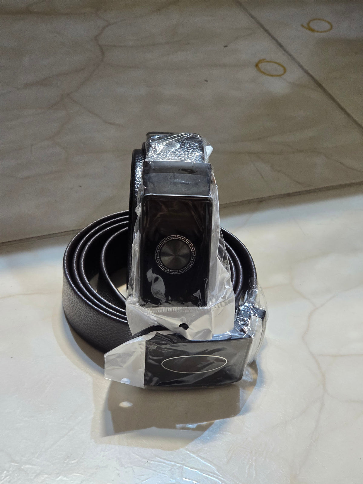 BioCode men's black leather belt with a patterned metal buckle, wrapped in protective plastic packaging.