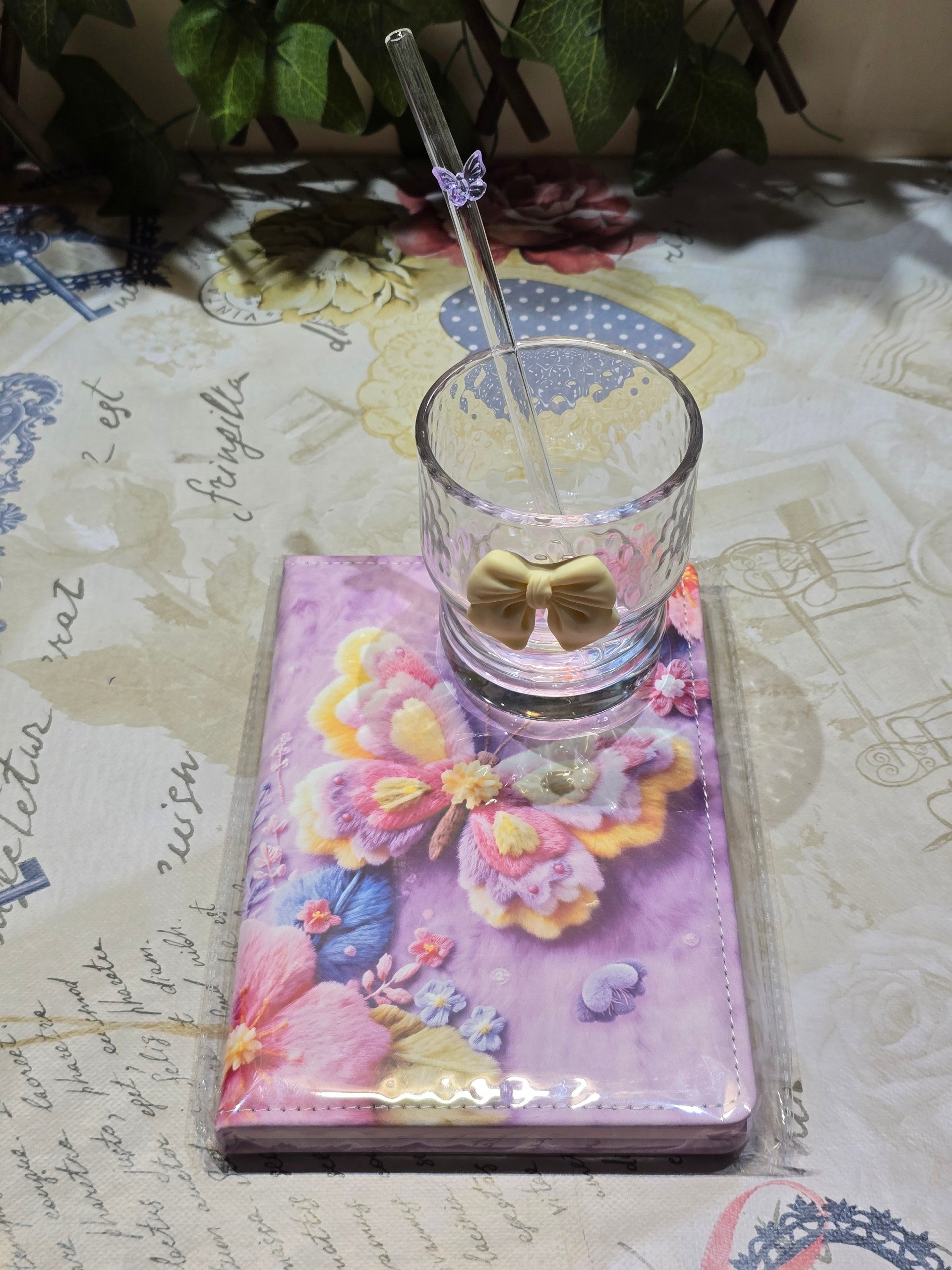 BioCode decorative glassware set featuring a textured glass tumbler with a cream bow, glass straw, and butterfly book.