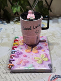 BioCode pastel pink insulated mug with Good Luck text and a matching butterfly embossed disc-bound notebook set