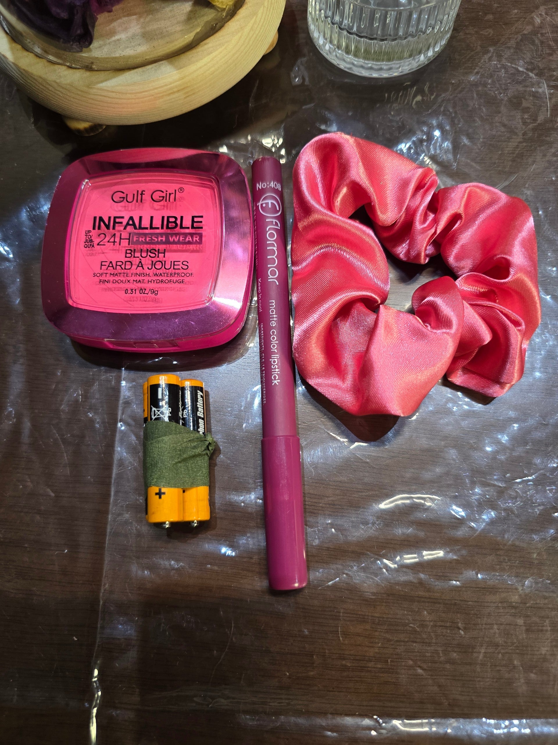 BioCode gift set featuring a pink blush compact, matte lipstick, and a satin scrunchie with two AA batteries.