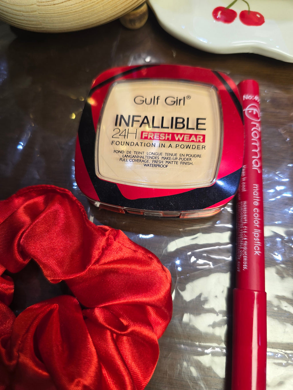 BioCode gift set featuring Gulf Girl foundation powder, Flormar red matte lipstick, and a red satin hair scrunchie.