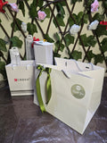 BioCode gift bags and packaging for CURREN watch and accessories set with green ribbon against a floral trellis