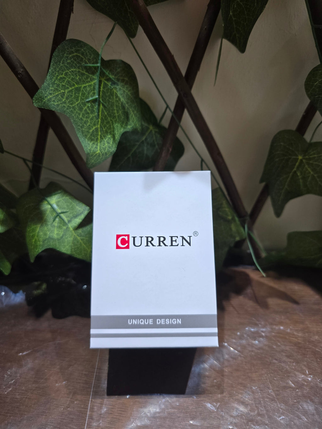 BioCode branded CURREN watch gift box with white packaging and unique design text against a leafy background