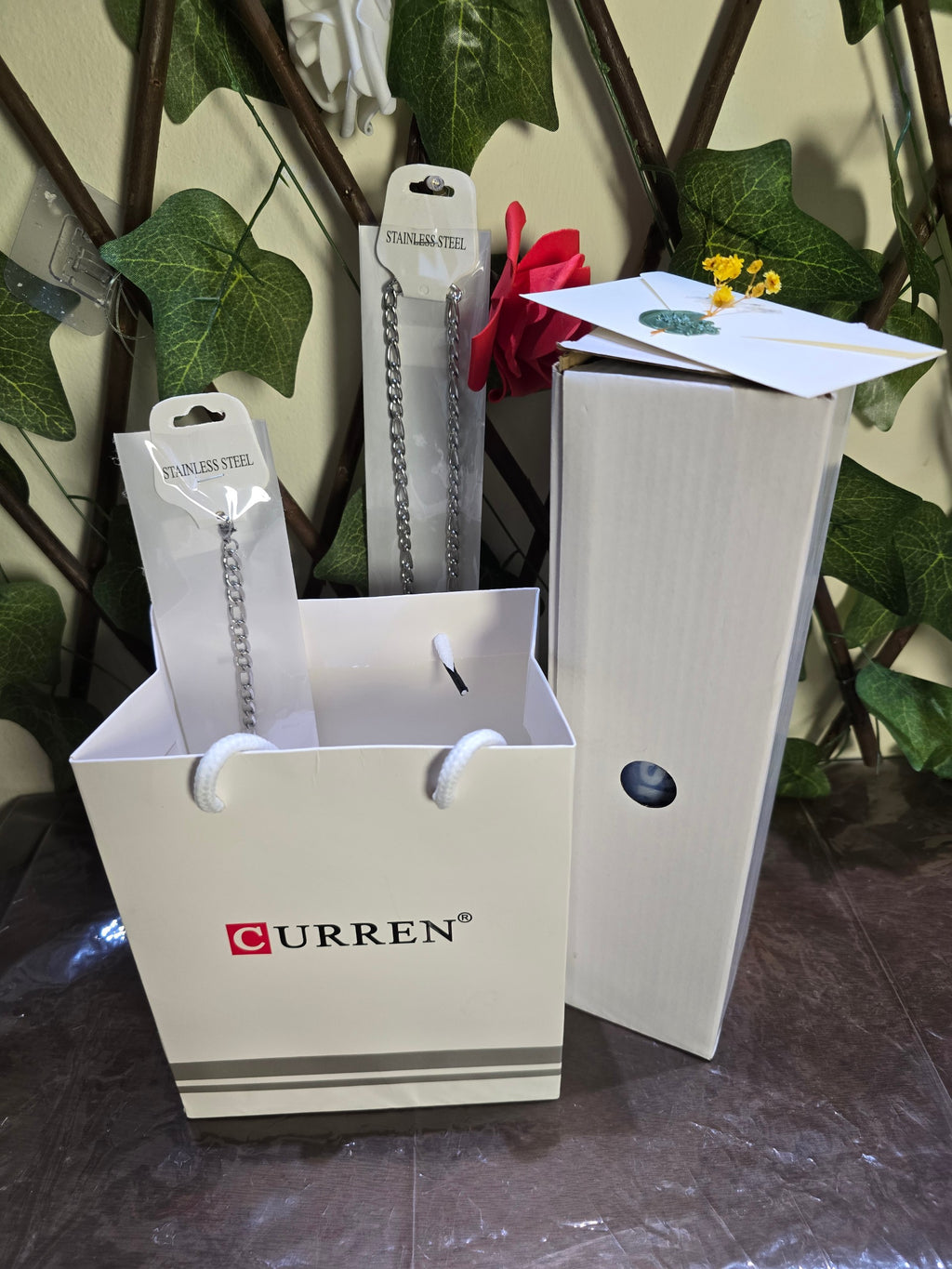 BioCode gift set featuring two stainless steel chains and a boxed watch with a blue sports water bottle in a gift bag