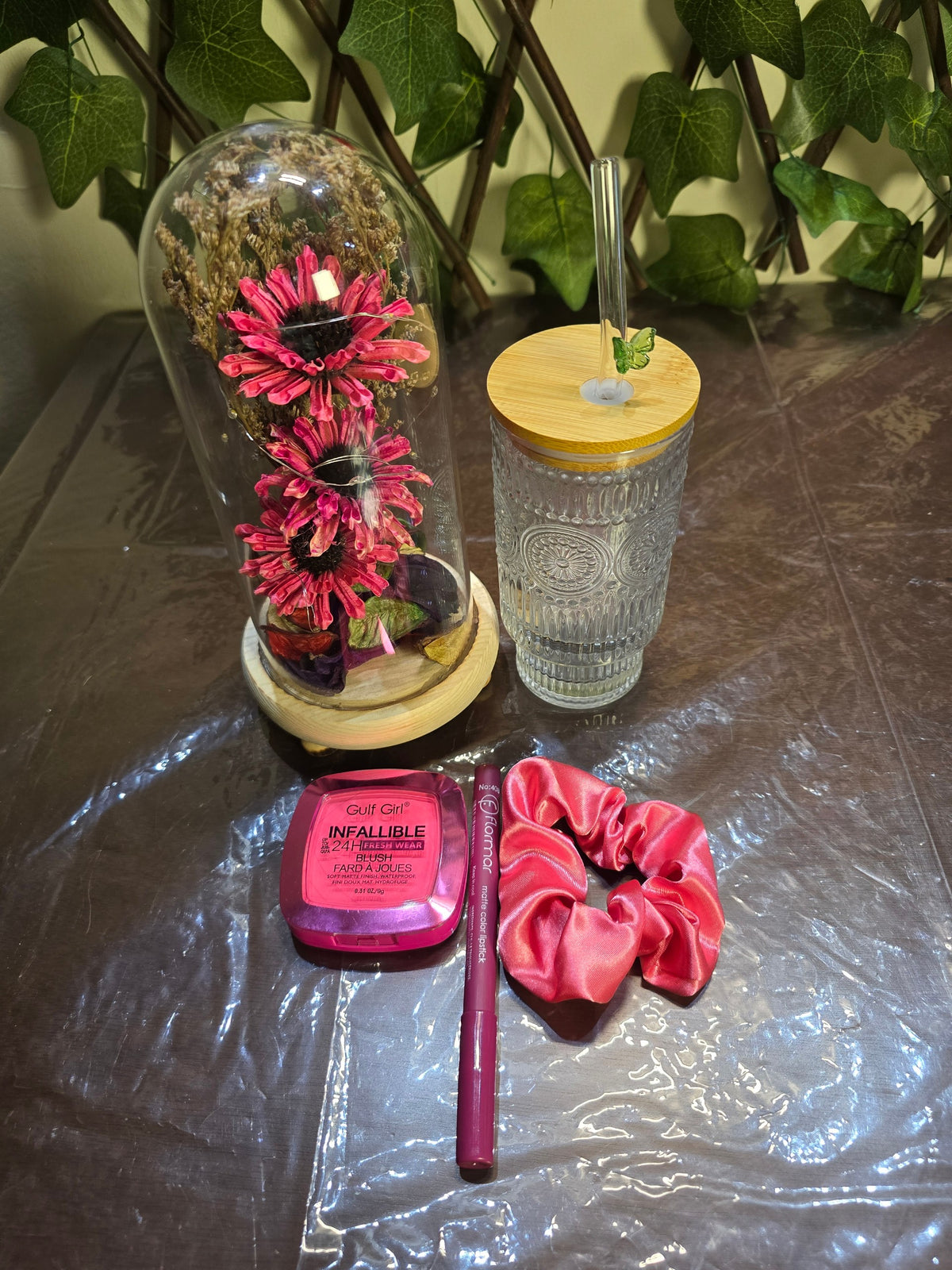 BioCode decorative gift set featuring a floral glass dome, textured glass tumbler, pink blush, lipstick, and scrunchie