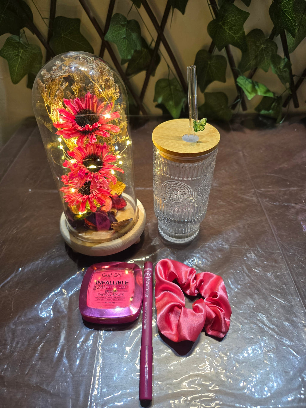 BioCode decorative gift set featuring a floral LED dome, glass tumbler, blush, matte lipstick, and pink satin scrunchie