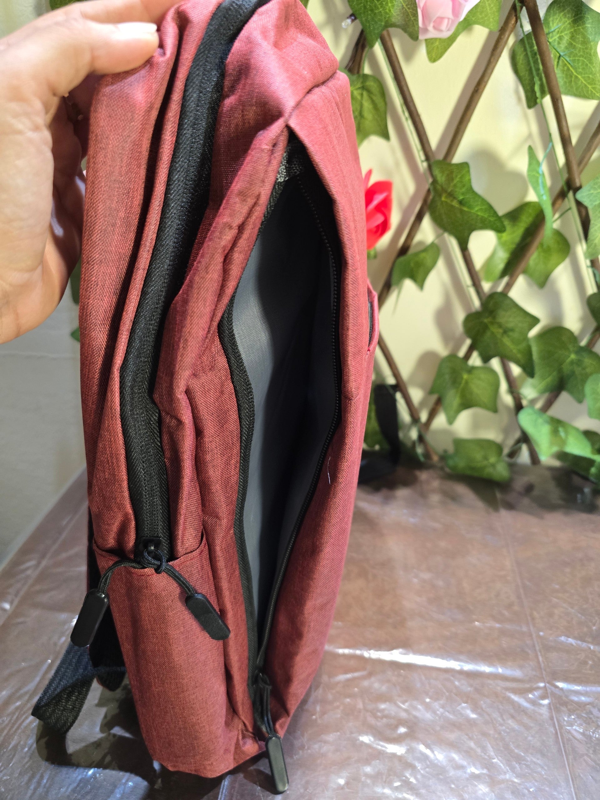 BioCode deep red laptop backpack with durable fabric, black zippers, and side pocket, side profile view.