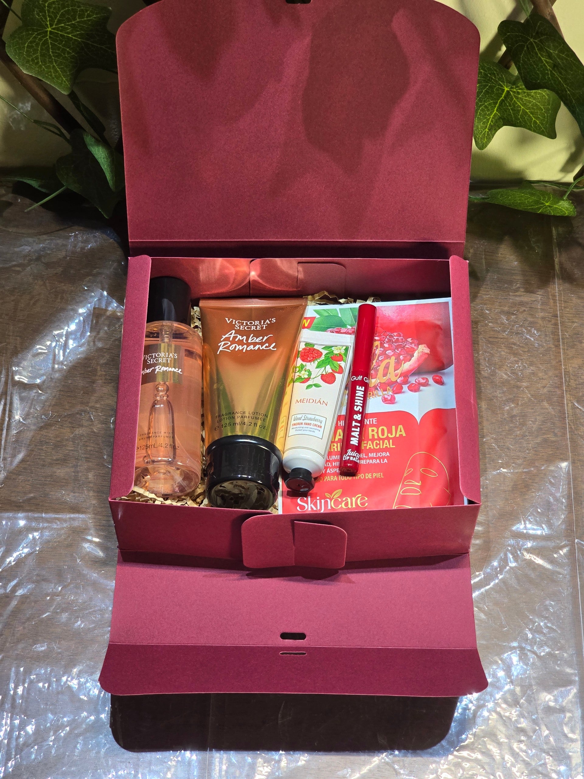BioCode beauty gift set in a burgundy box with Victoria's Secret fragrance, hand cream, lip balm, and facial mask.