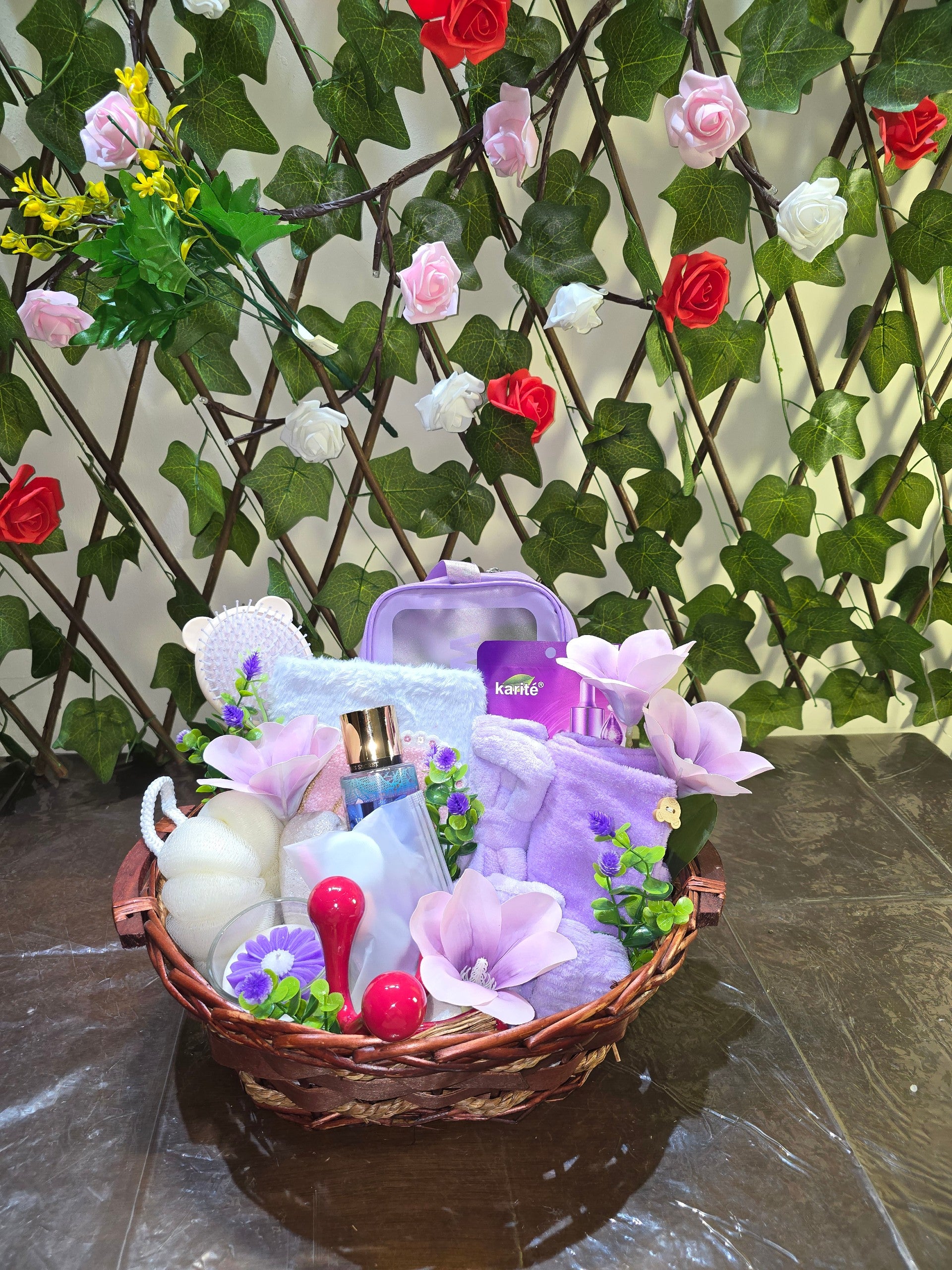 BioCode deluxe self-care pamper gift hamper with skincare essentials, purple accessories, and spa tools in a basket.