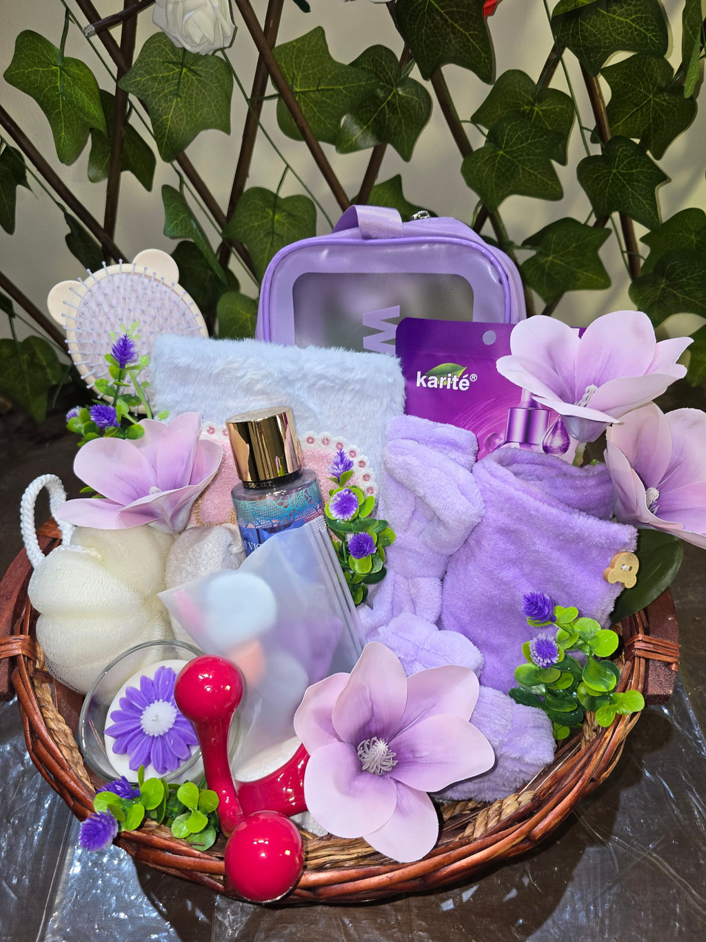 BioCode deluxe self-care gift hamper featuring purple spa accessories, skincare products, and a floral candle in a basket