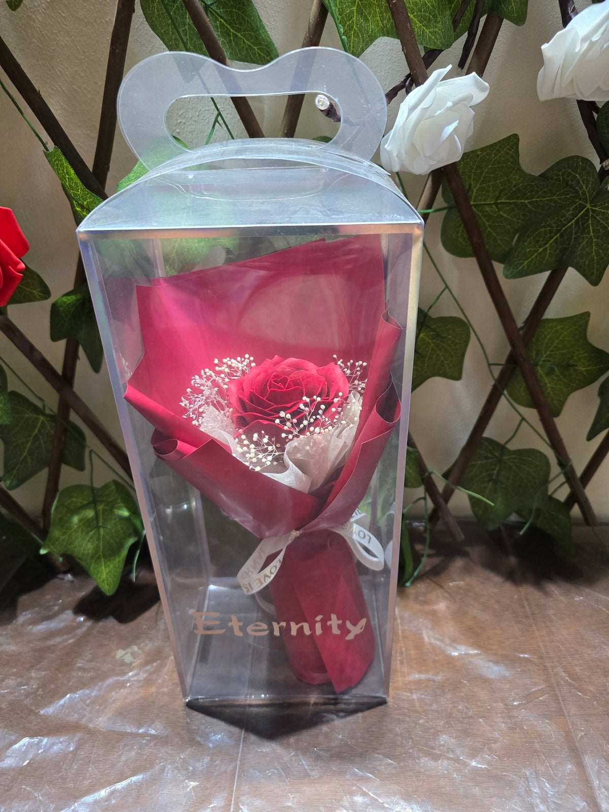 BioCode Eternity single red artificial rose bouquet with baby's breath in a clear presentation gift box with handle