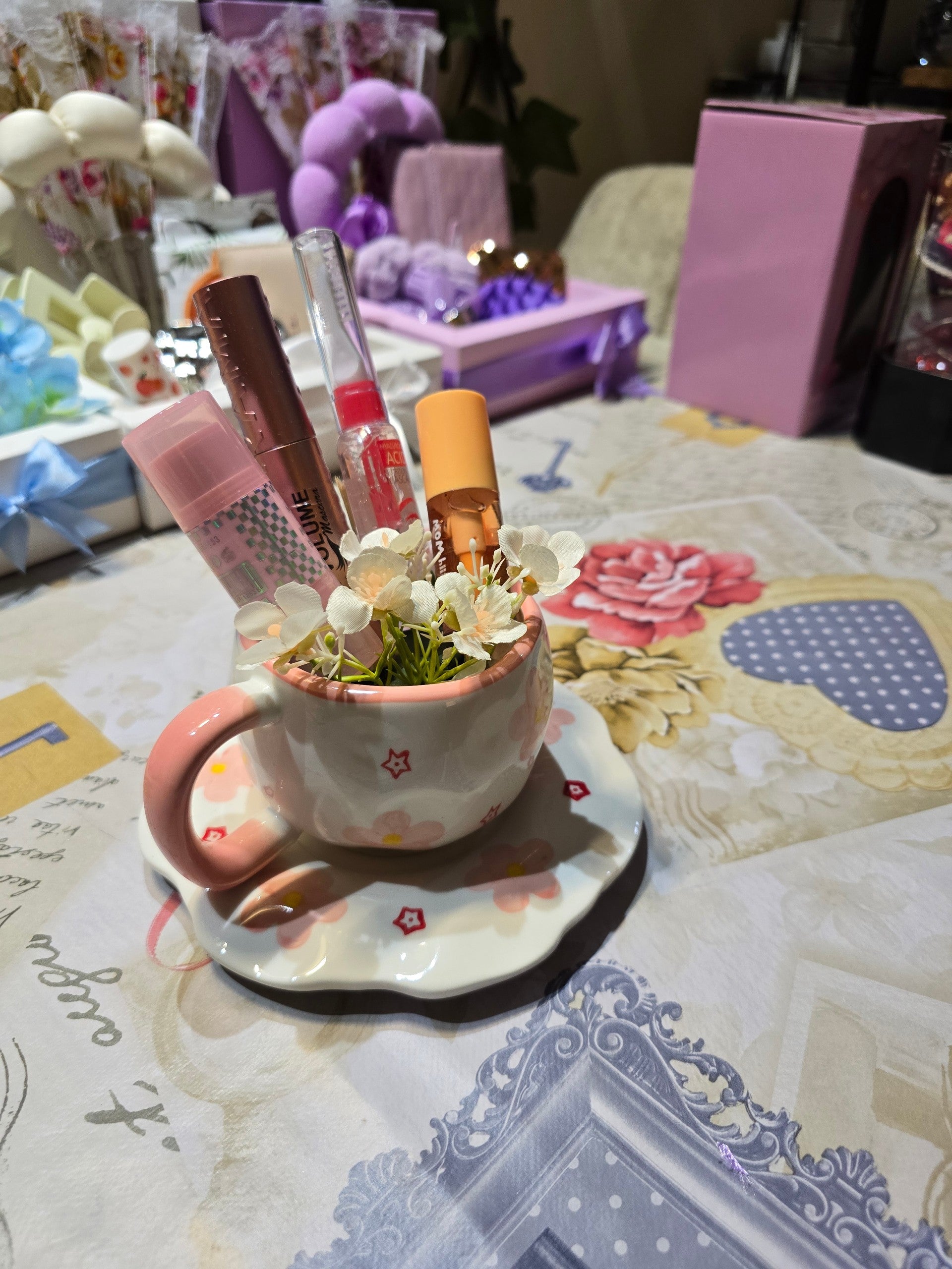 BioCode ceramic teacup and saucer with pink floral motifs and star accents, used as a makeup brush organiser