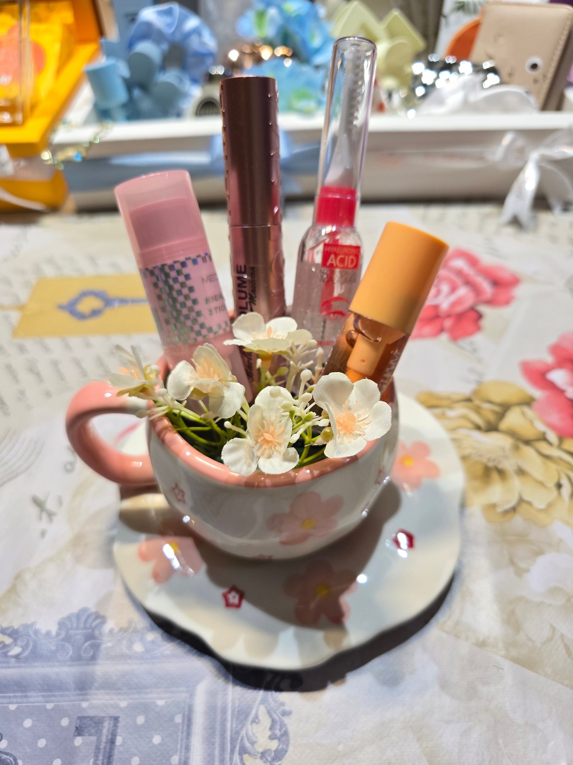 BioCode floral ceramic teacup and saucer used as a decorative makeup brush holder with pink flower accents