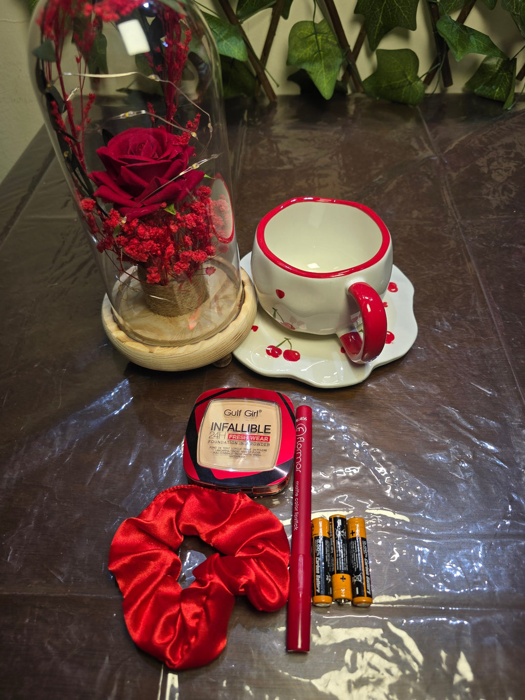 BioCode gift set with preserved red rose in glass dome, cherry cup and saucer, foundation powder, lipstick, and scrunchie