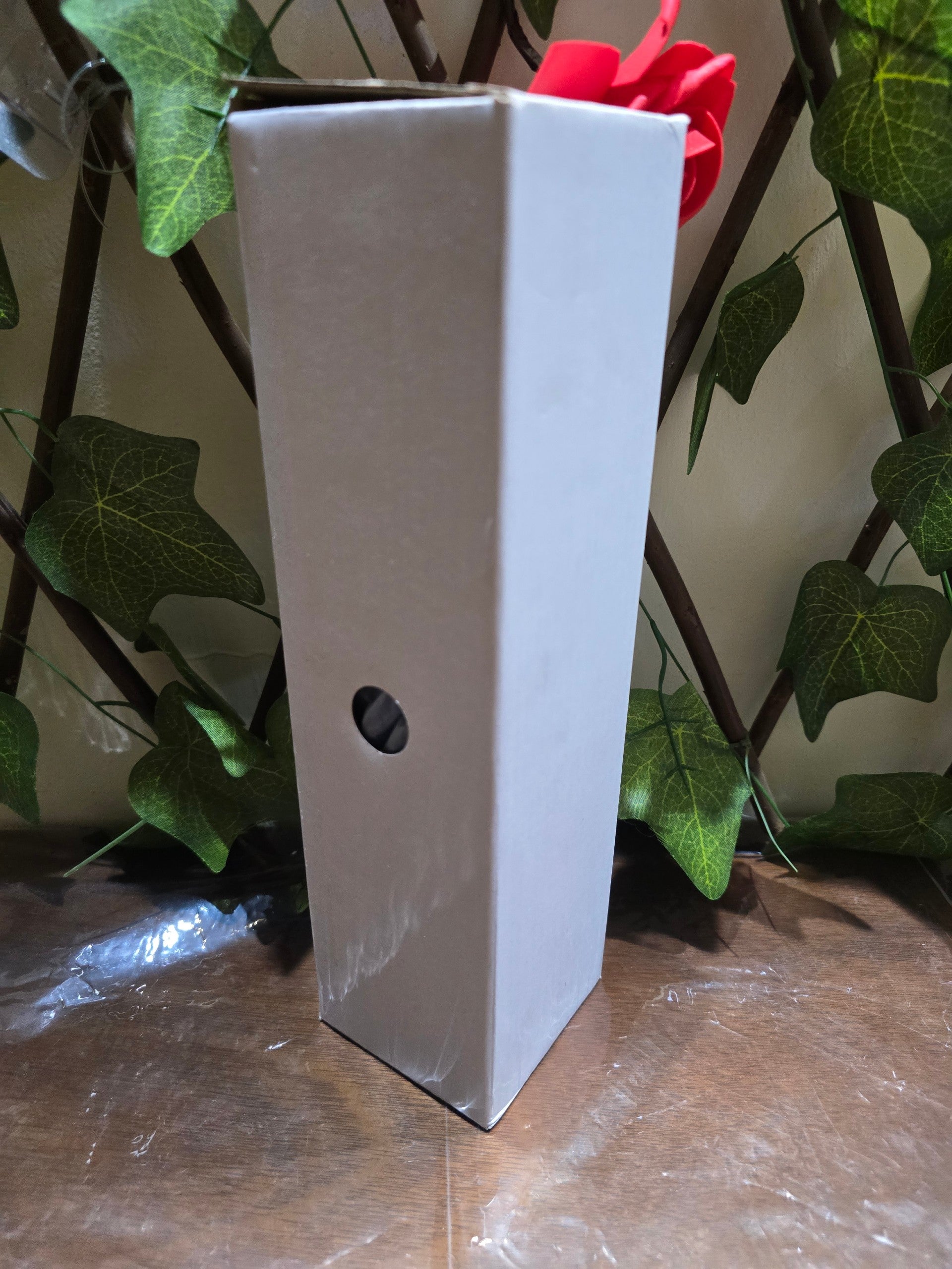 BioCode gift set packaging box in white, featuring a small circular cutout, displayed against a decorative ivy backdrop.