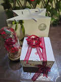 BioCode gift set featuring a preserved red rose in a glass dome, cosmetics, and a gift box with a red ribbon.