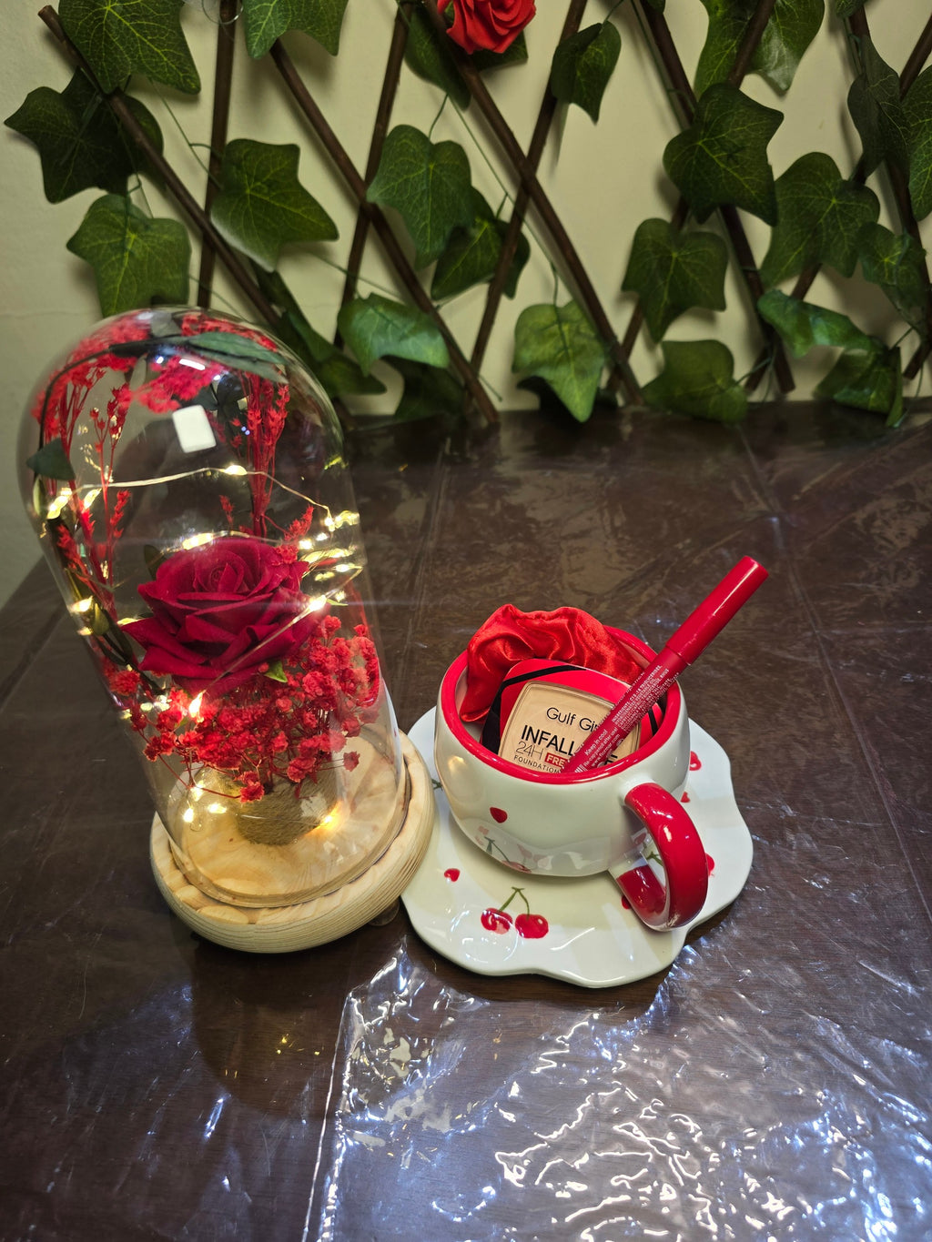 BioCode gift set featuring a preserved red rose in a glass dome with fairy lights, cherry cup, and beauty cosmetics.