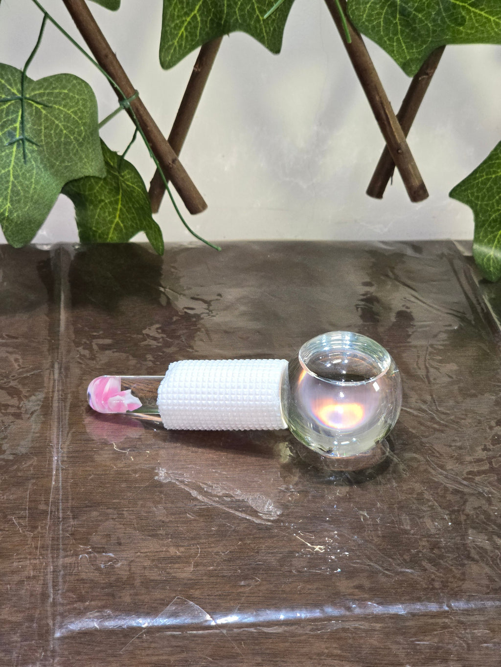 BioCode glass cooling globe for facial massage with a white textured grip and pink floral detail on the handle
