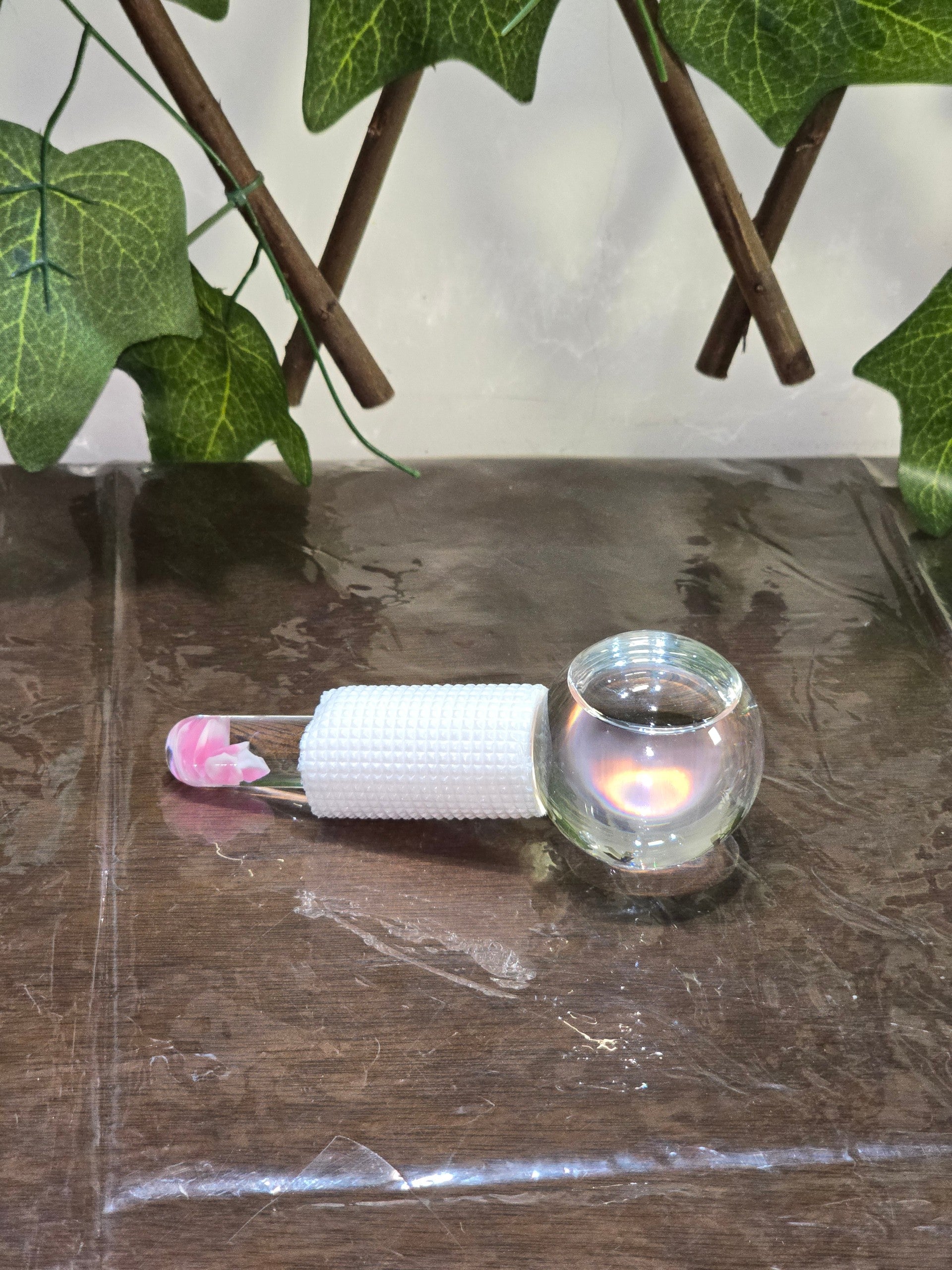 BioCode glass cooling globe for facial massage with a white textured grip and pink floral detail on the handle