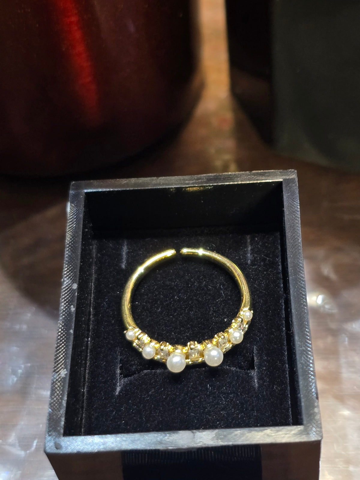 BioCode gold-toned ring with pearls and sparkling stones inside a black velvet gift box
