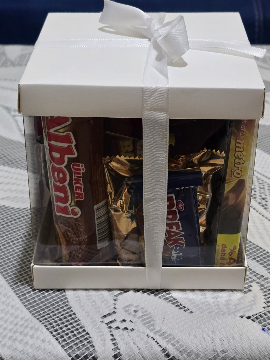 BioCode Happiness Box gift set featuring assorted premium chocolates and snacks in a white box with a white ribbon.