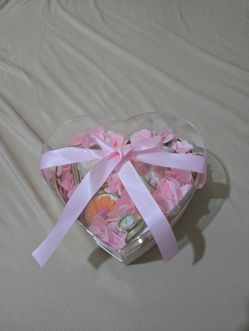 BioCode heart-shaped gift box with pink faux petals, a gold-toned wristwatch, and a decorative mug tied with a ribbon