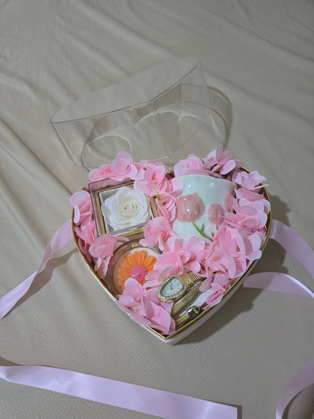 BioCode heart-shaped gift box filled with pink faux petals, a gold wristwatch, decorative mug, and preserved white rose.