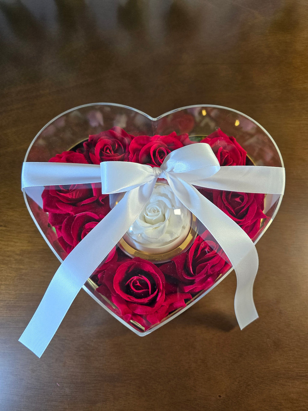 BioCode heart-shaped gift box with preserved red roses and a central white rose, tied with a white satin ribbon bow.