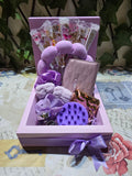 BioCode lilac self-care gift set featuring a headband, wrist cuffs, scalp massager, mirror, wallet, and lace fan.