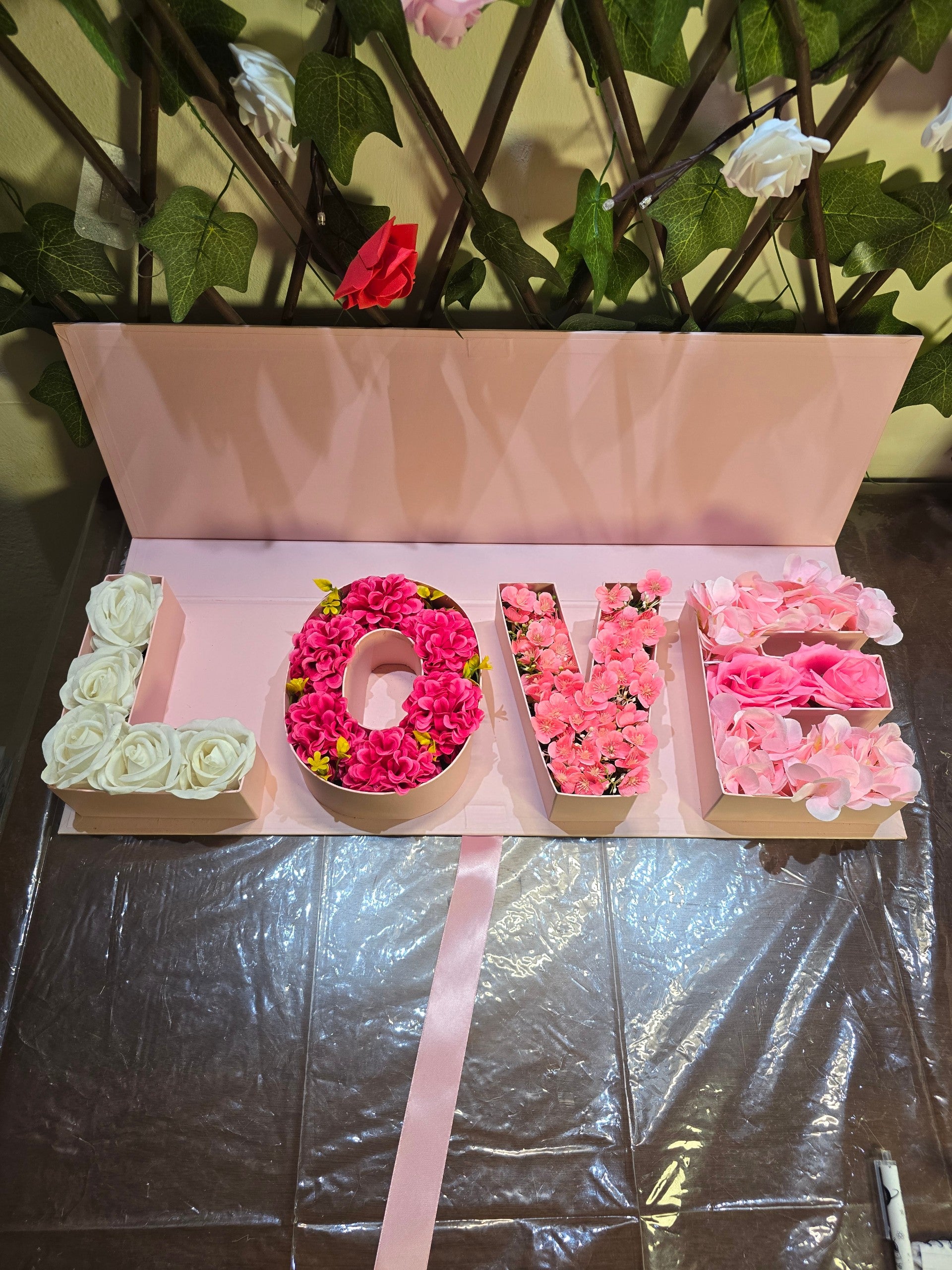 BioCode LOVE floral gift box with artificial white, pink, and blush flowers in a pastel pink presentation box.