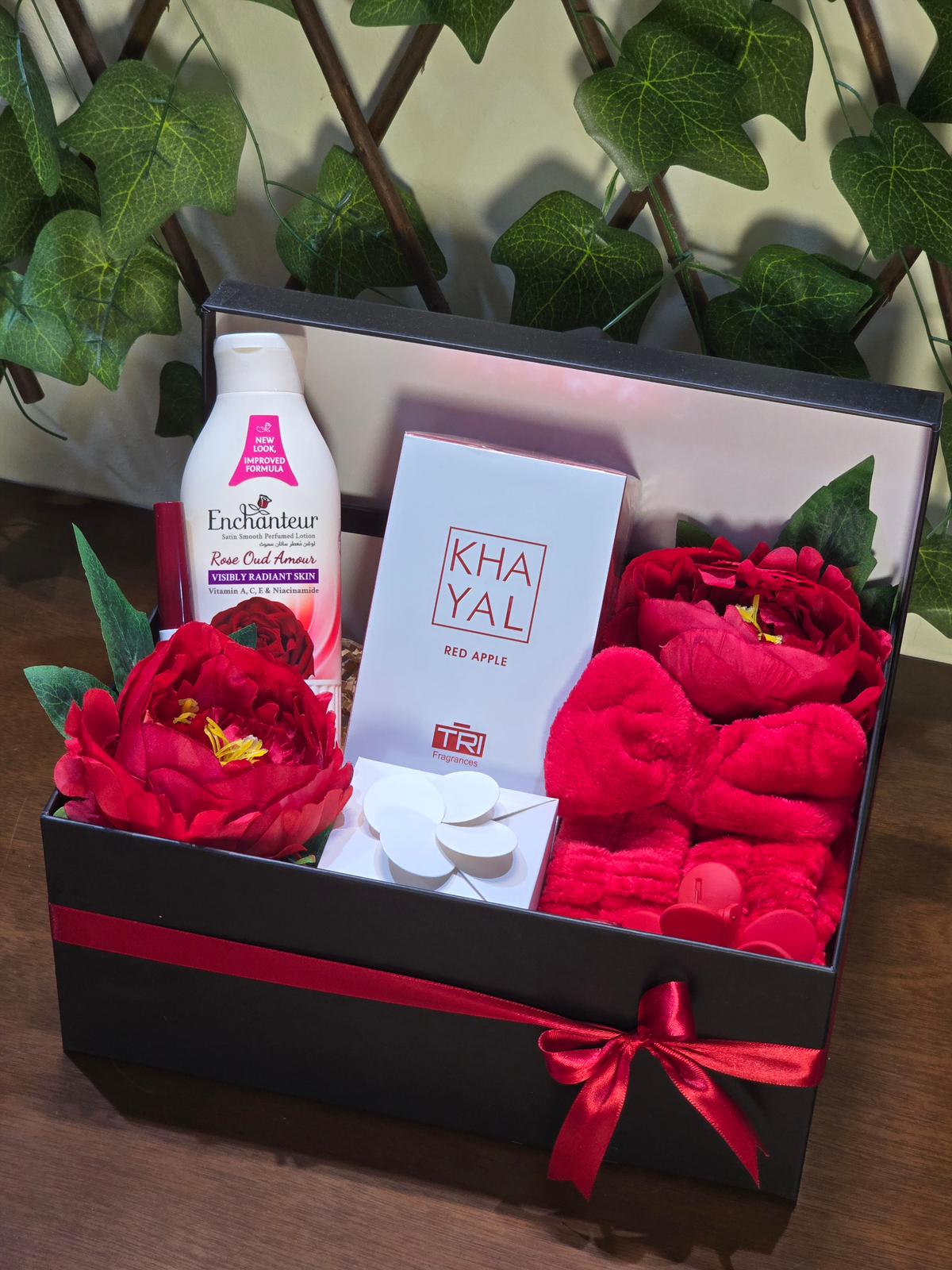 BioCode luxury pampering gift set in a black box with red ribbon, featuring Khayal perfume, Enchanteur lotion, and red floral accents.
