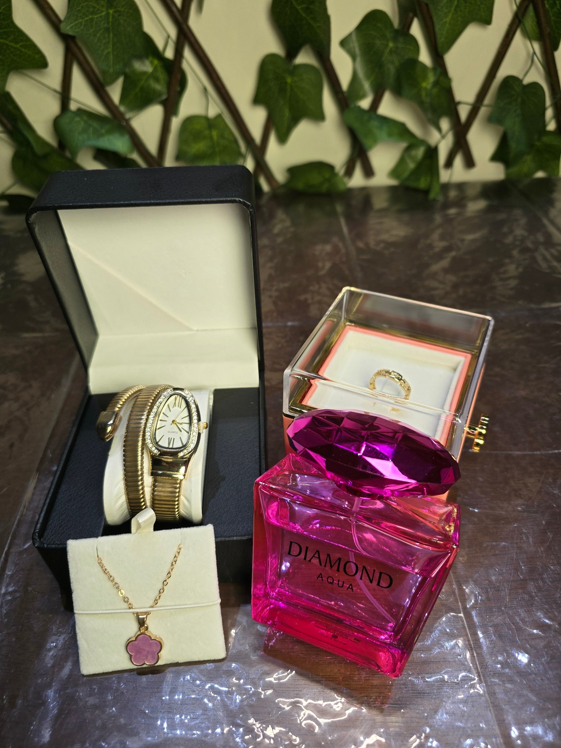 BioCode luxury gift set with Diamond Aqua perfume, gold snake watch, floral necklace, ring, and preserved pink rose.