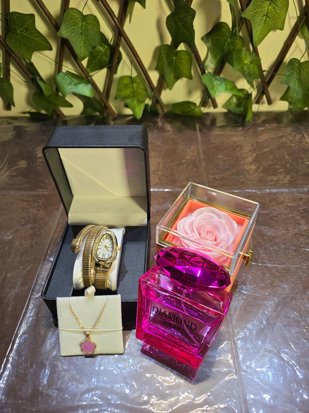 BioCode luxury gift set featuring Diamond Aqua perfume, gold snake watch, floral necklace, ring, and preserved rose.