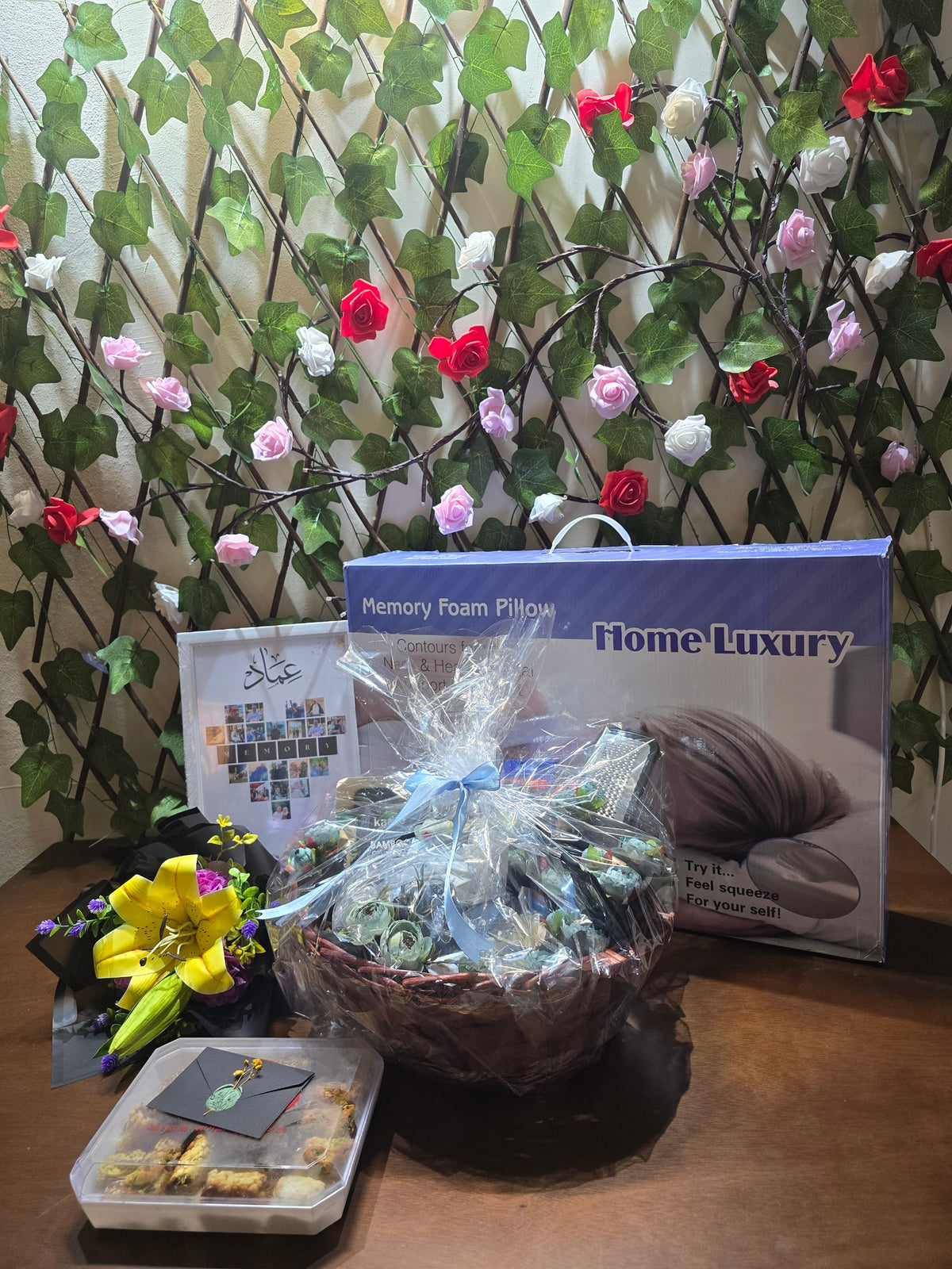 BioCode men's grooming gift hamper featuring a memory foam pillow, personal care items, and a decorative floral display