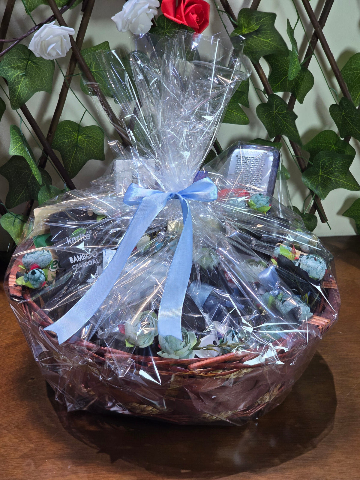 BioCode men's grooming gift hamper in a woven basket wrapped in clear cellophane with a blue ribbon bow
