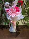 BioCode artificial pink lily and hydrangea bouquet wrapped in white paper with a pink satin ribbon
