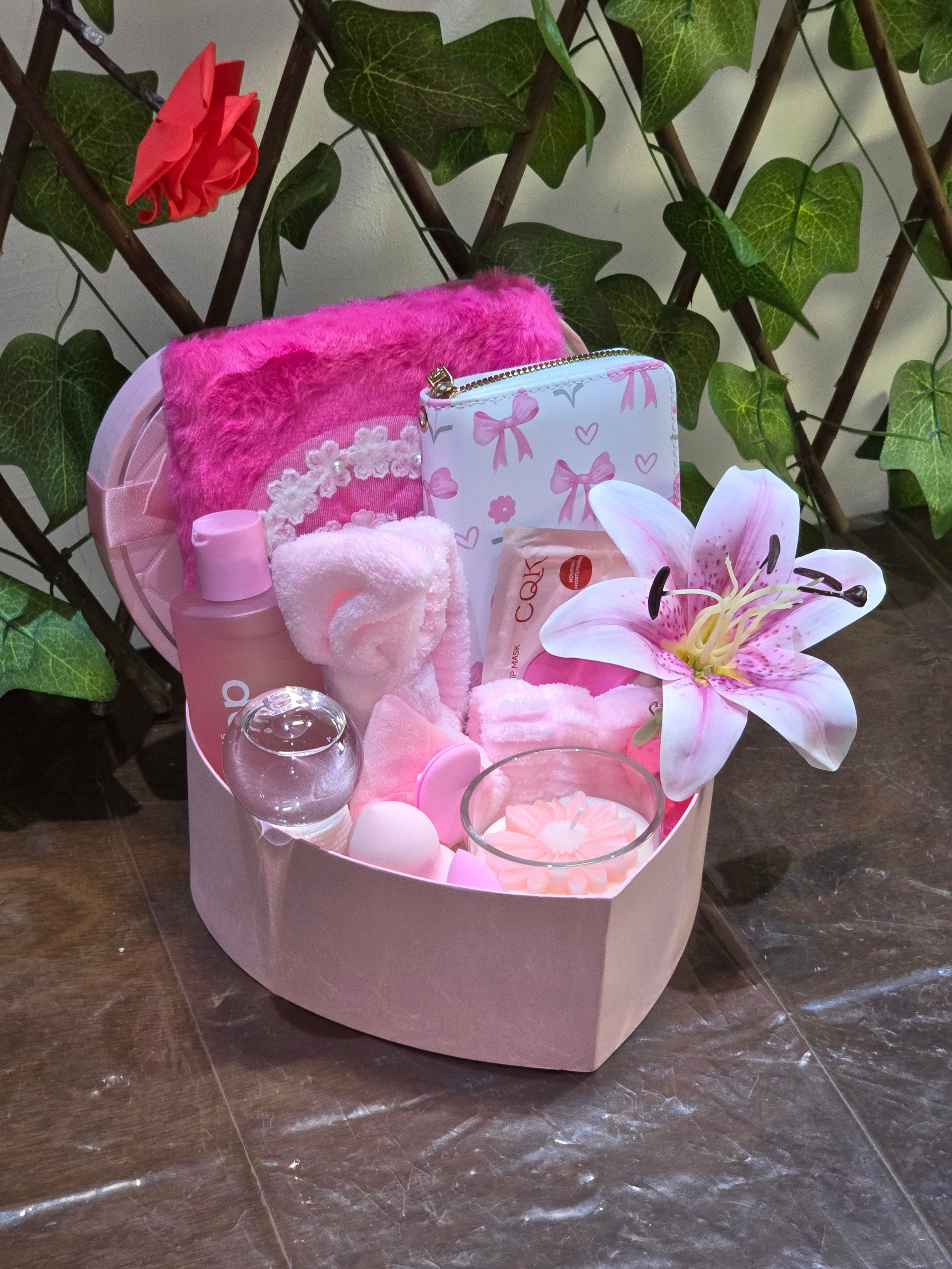 BioCode pink self-care gift set in a heart box with skincare, plush accessories, floral candle, and beauty tools.