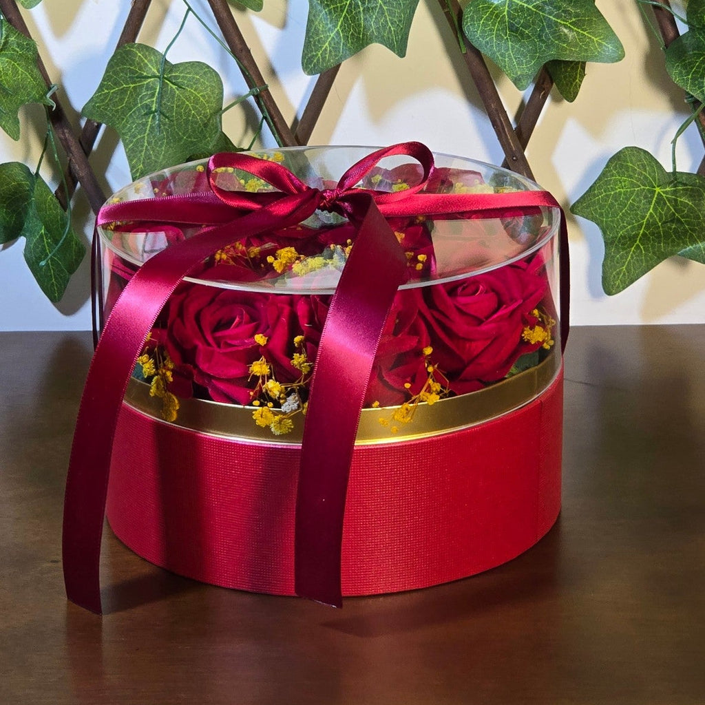BioCode preserved red rose gift box with clear lid and satin ribbon, accented with yellow filler flowers