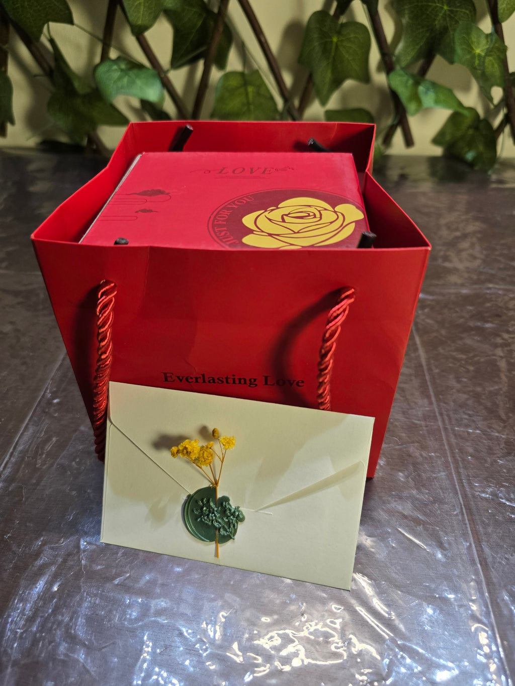 BioCode preserved rose jewellery gift box in a red bag with a wax-sealed envelope featuring dried yellow flowers